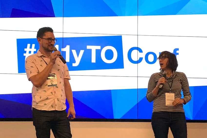 Eric Bailey & I on stage in front of the #a11yTO event logo