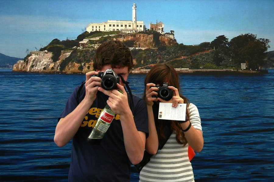 Photo of two people holding cameras to their faces